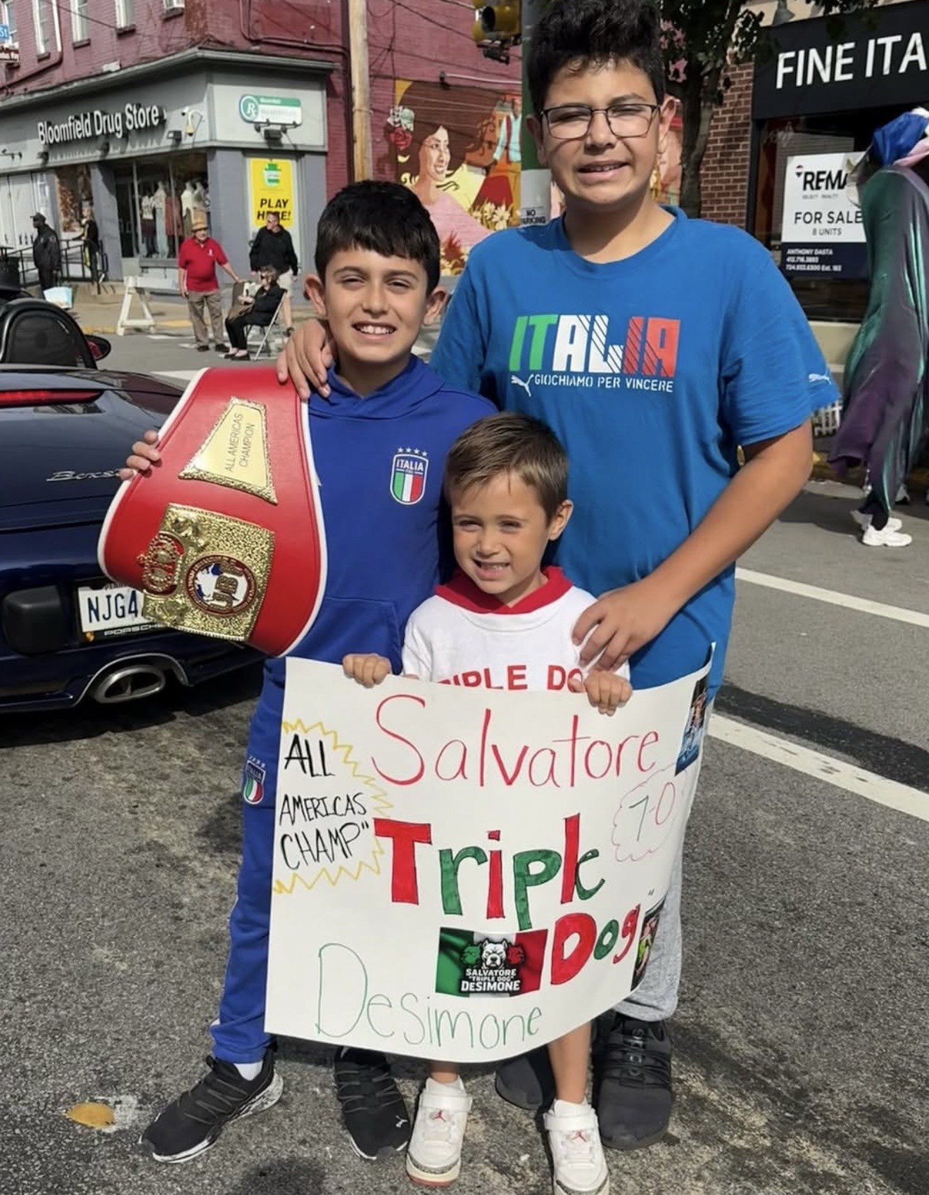 Three young supporters with the UBF belt and their handmade Salvatore Triple Dog DeSimone sign.
