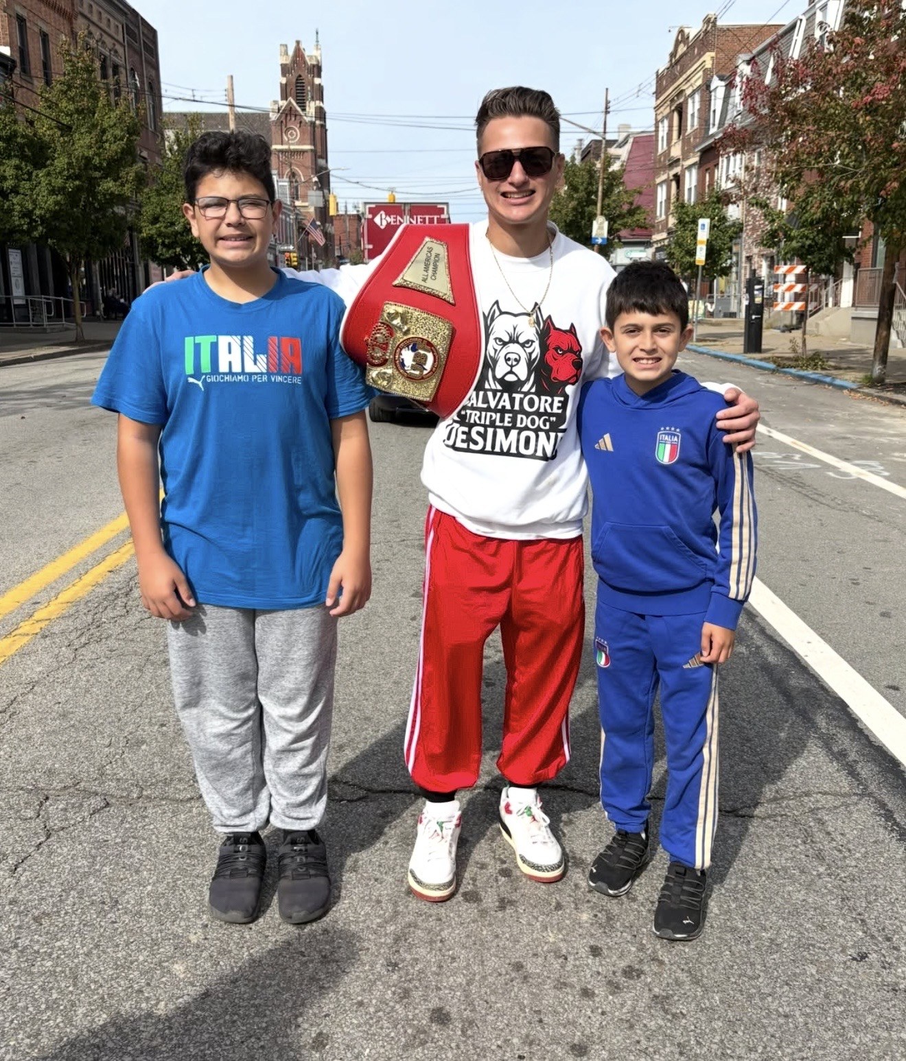 DeSimone poses with two young supporters and his UBF championship belt.
