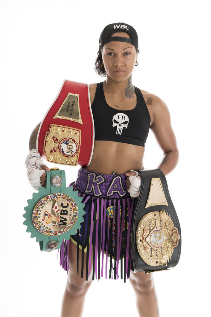 Kali Reis holding her championship belts